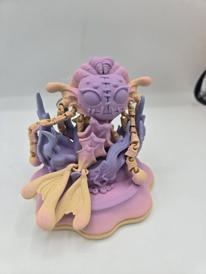 Spooky Mermaid Doll 3D print in pastel pink, purple and cream, posed upright on a wavy display base with articulated arms and tail fins
