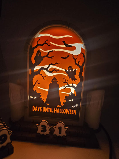 Vampire Halloween Countdown lit at night — close-up of the glowing orange tombstone window with vampire, ghosts, and bats above the 31 days until Halloween tiles