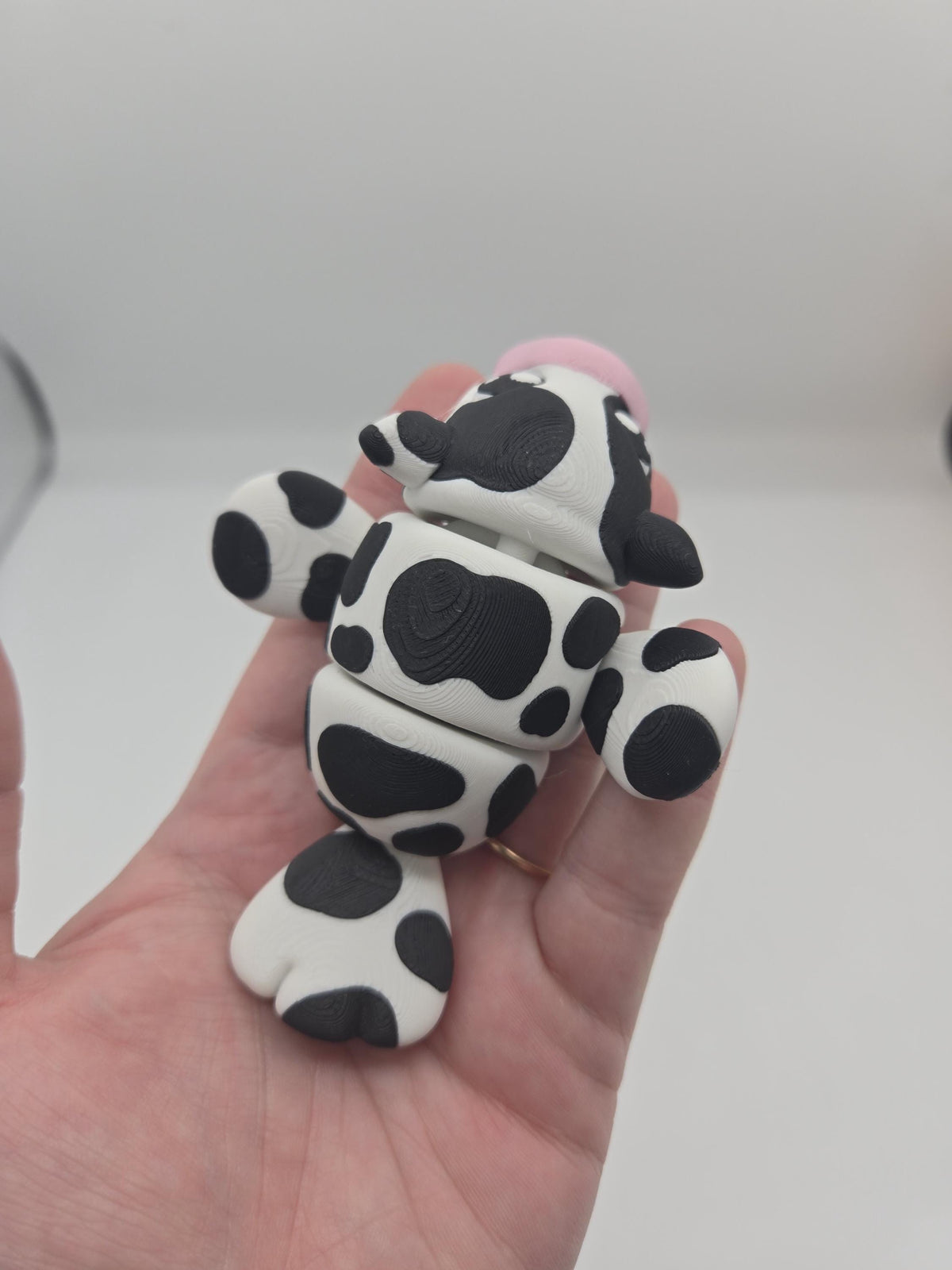 Sea Cow Manatee flexi 3D print held in hand, underside view showing the articulated belly segments, flippers, and tail