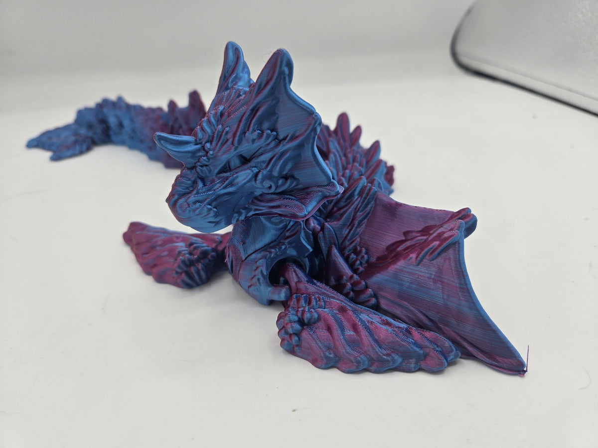 Ocean Sea Dragon flexi 3D print front view with head lowered and wing fins spread wide, showing the face and flipper claws in Blue-Purple Dual