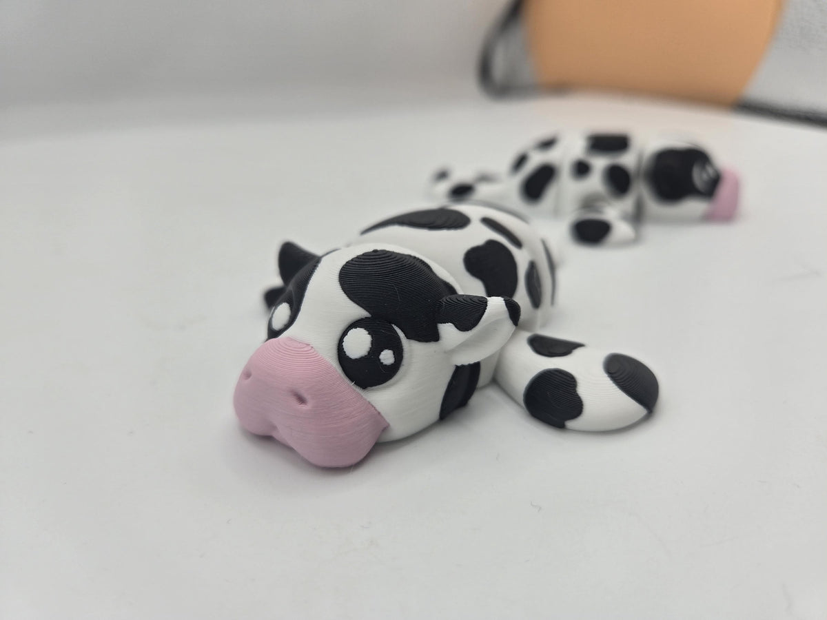 Sea Cow Manatee flexi 3D print front view with pink nose and big eyes, second cow-spotted manatee in the background