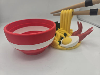 Ramen Bowl Display and Stash 3D print empty red bowl with white stripe in front, the removable noodle and egg topper behind it