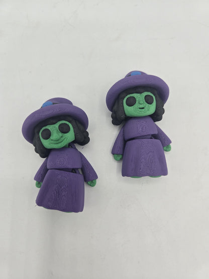 Tiny Witch Articulated Flexi Mini 3D print pair lying on a white surface, long-nose and regular-nose versions in purple robes with black curly hair