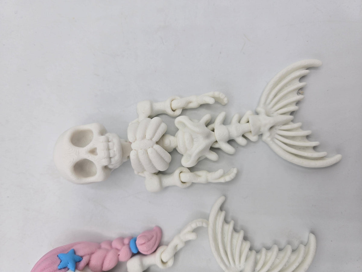 Flexi Mermaid Skeleton 3D print close-up of the plain white style showing hollow-eyed skull, ribcage, hinged arm joints and bony mermaid tail