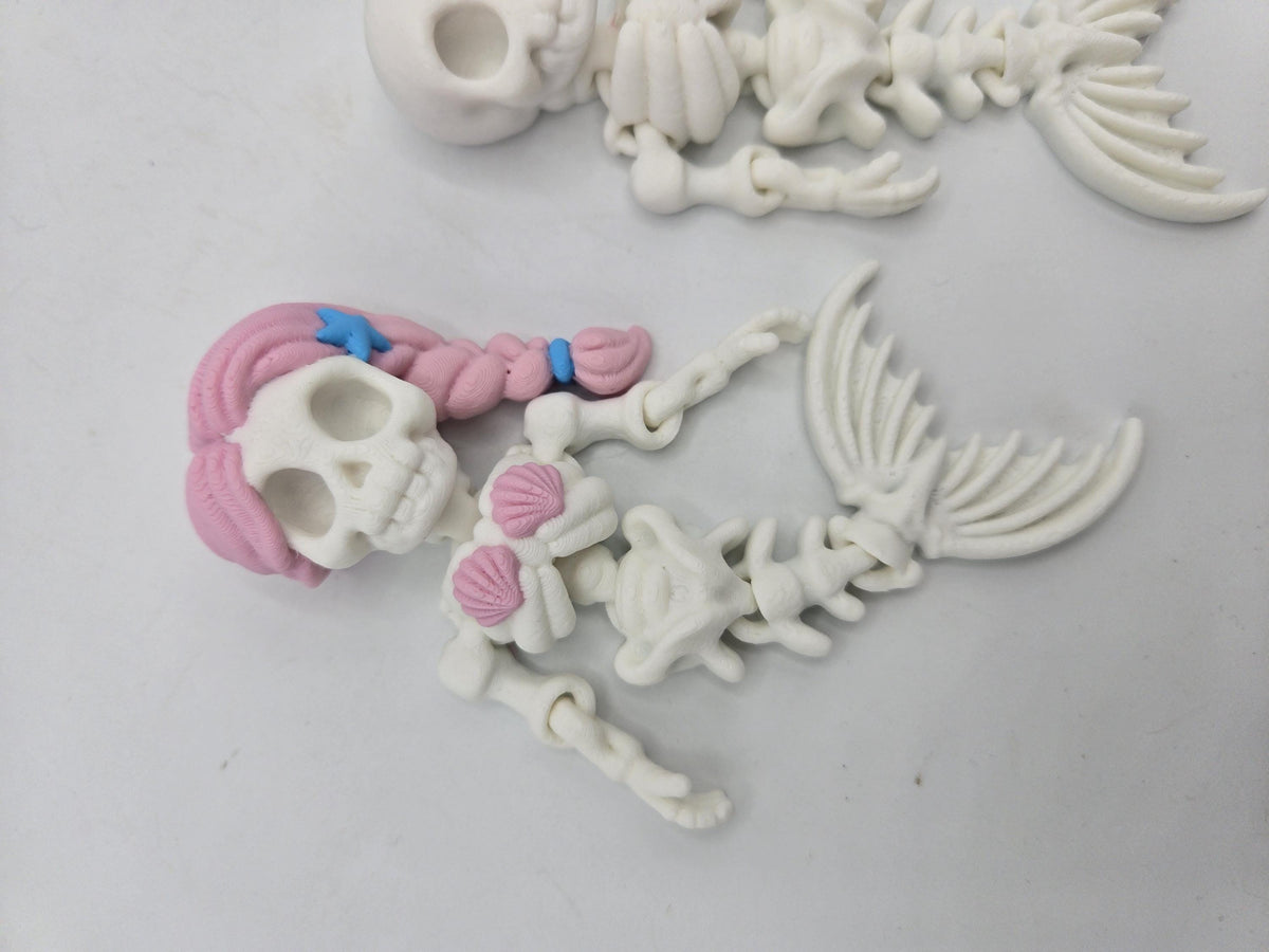 Flexi Mermaid Skeleton 3D print close-up of the Hair + Clam Shells style with pink braided hair, blue starfish hair clip, pink seashell top and jointed spine