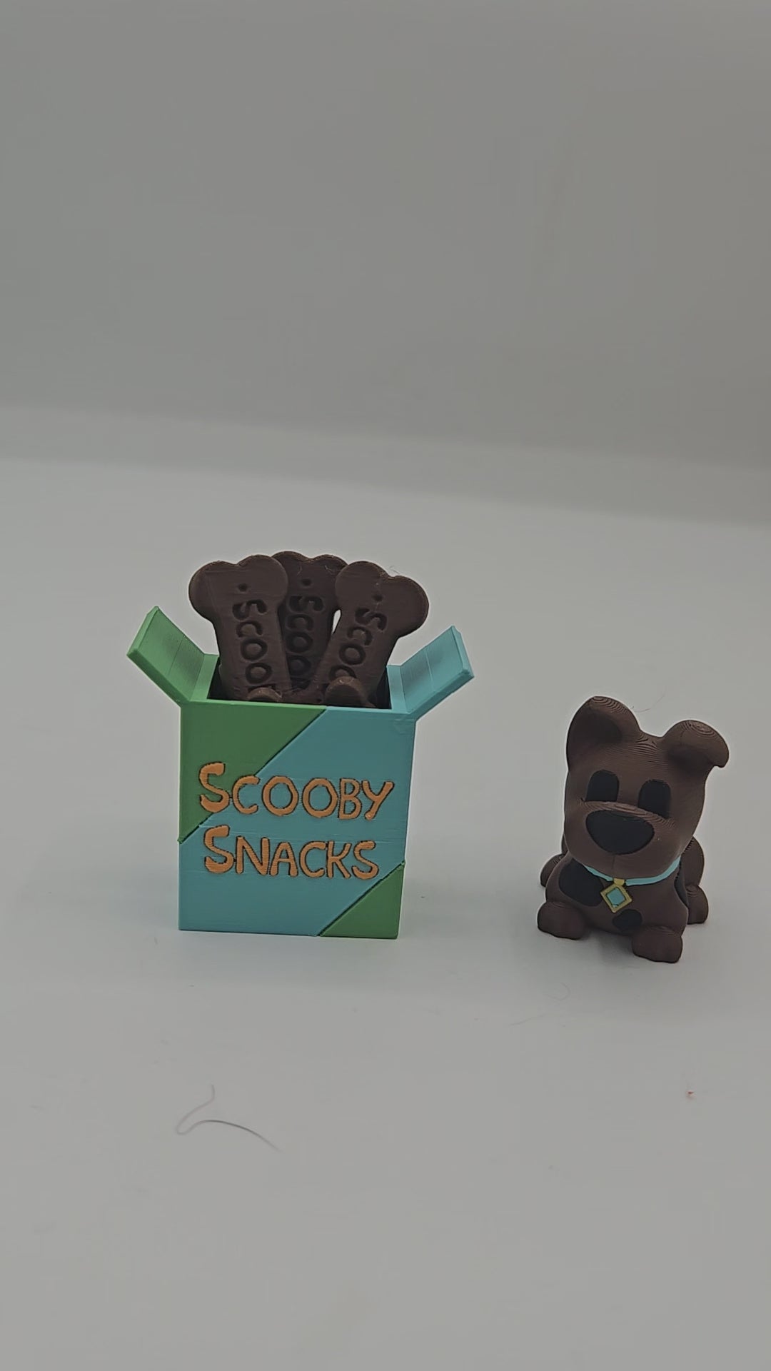 Video of the Scooby Snacks key clicker and mini Scooby Doo inspired dog figurine 3D print set on a desk