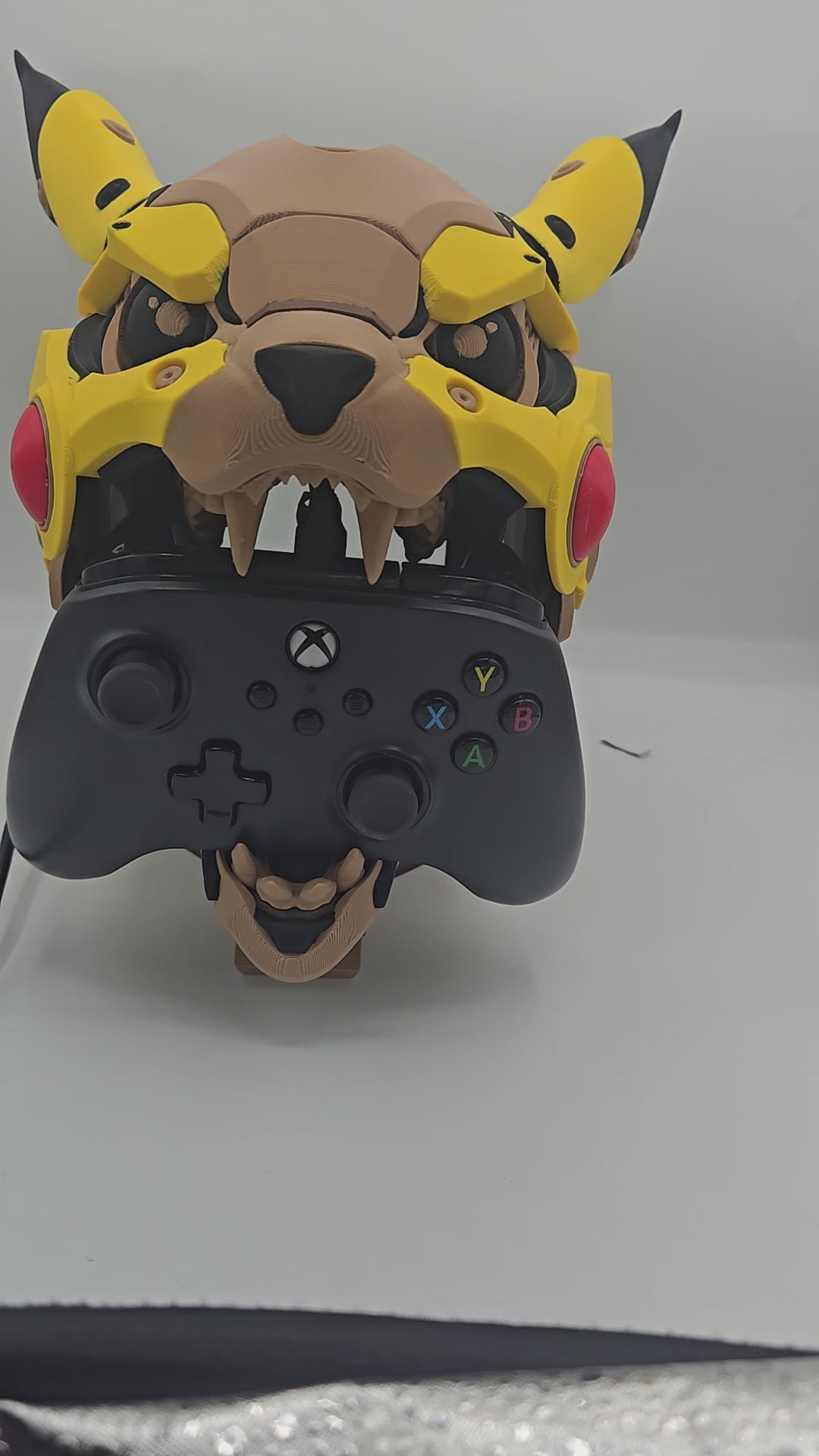 Video of the Mekachu Mecha Monster controller holder 3D print, a mecha-armored creature head with an opening jaw designed to hold a gaming controller on display